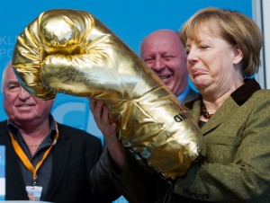 Angela Merkel egy aranyszínű óriás bokszkesztyűvel. Forrás: or-argent.eu, Conclude Zrt.